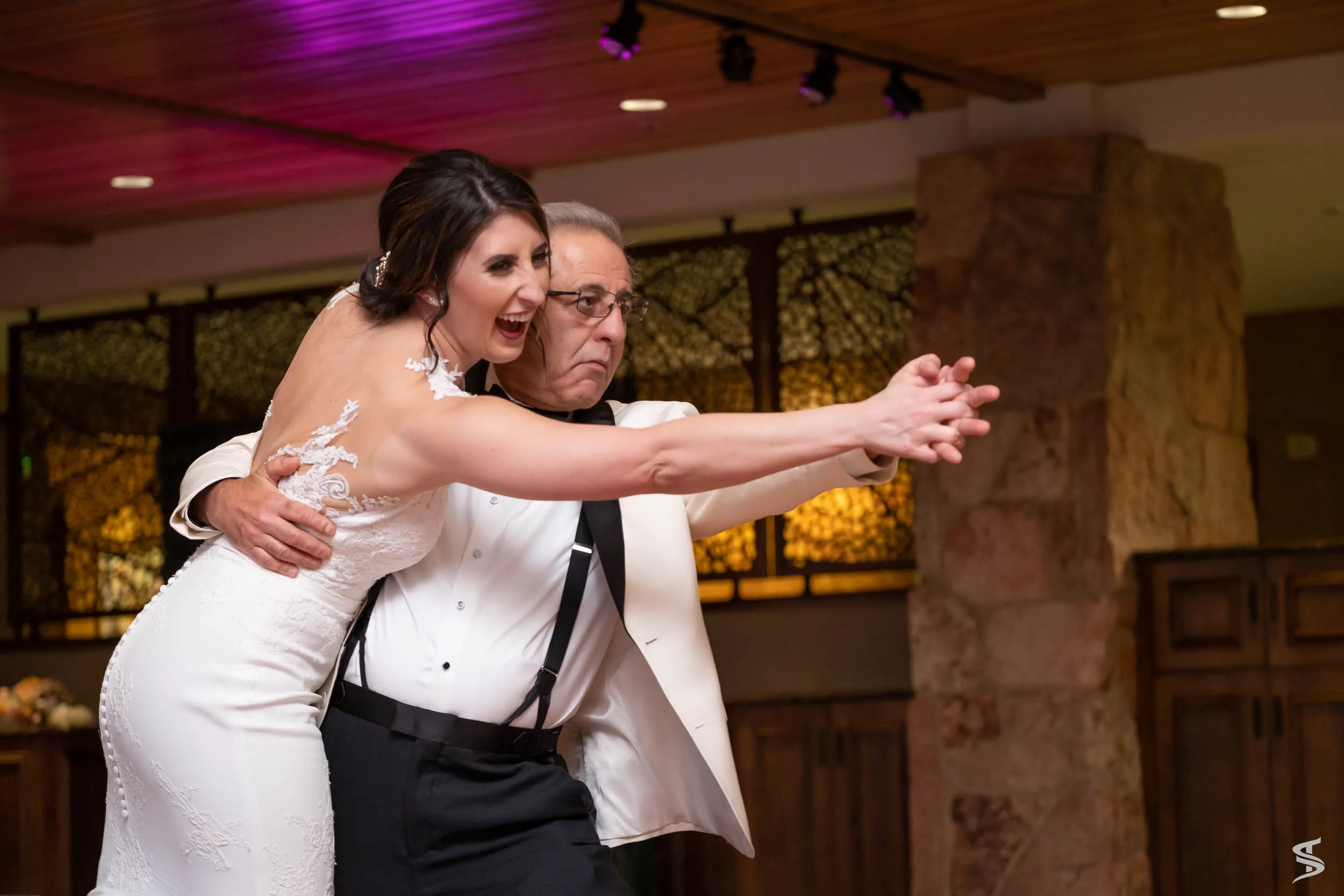 Bride laughing during a father-daughter dance with her father at her wedding reception at Garden of the Gods, Colorado.