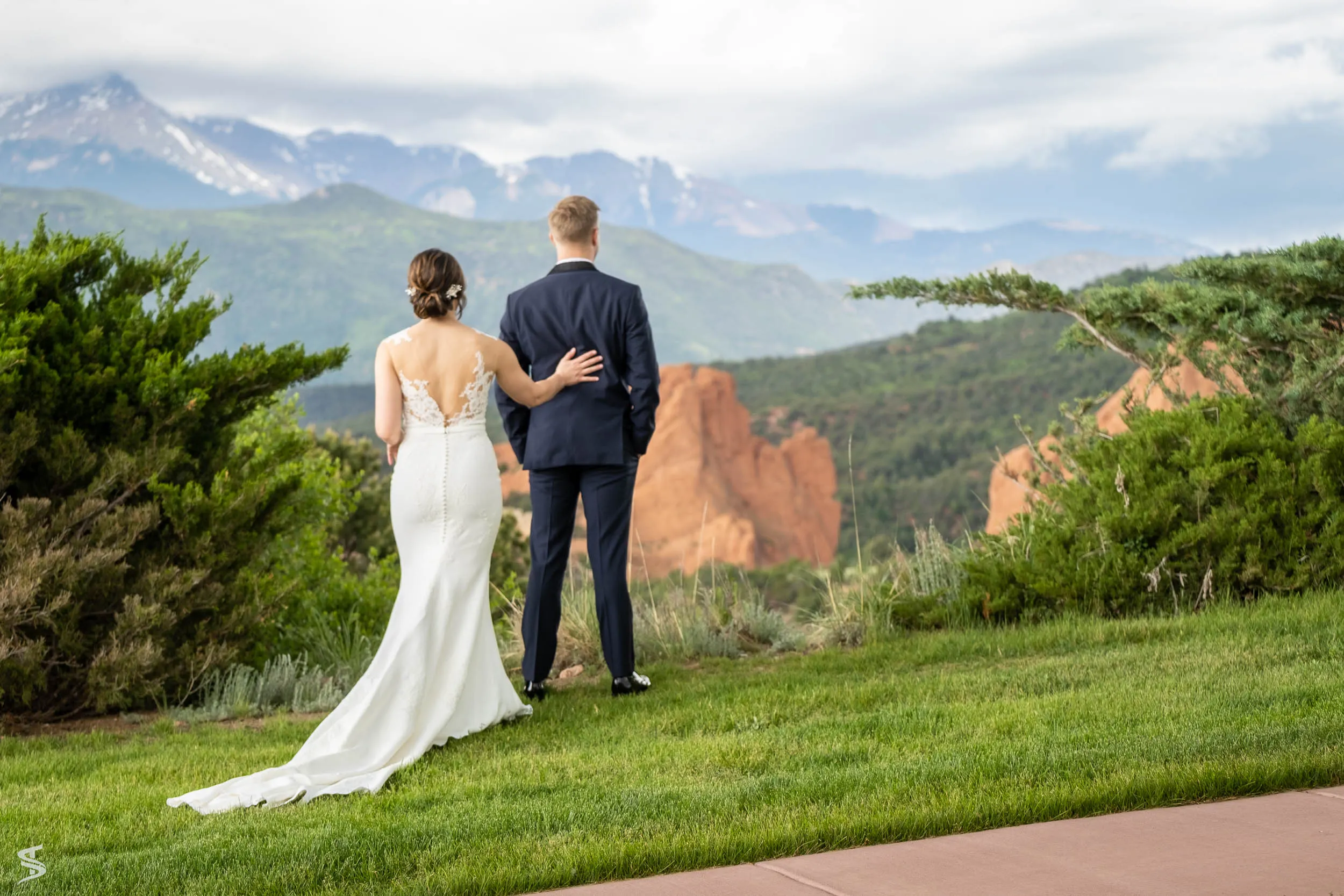 Newlyweds overlooking red rock formations and distant mountains